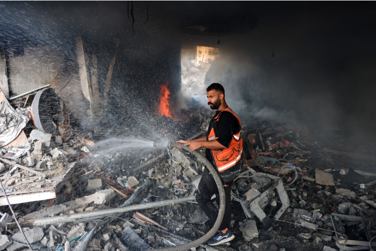 A firefighter tries to extinguish a fire in a destroyed building following an Israeli strike on Al-Jalaa Street in Gaza City on July 24, 2026. Gaza continues to face daily violence amid accusations from both sides of ceasefire violations, with widespread destruction and displacement leaving many people living in tents and temporary shelters. Omar Al-Qattaa/AFP via Getty Images